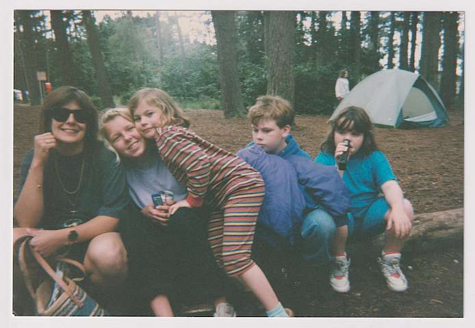 Beverley Burnett and four children sitting on a tree trunk (camping trip)